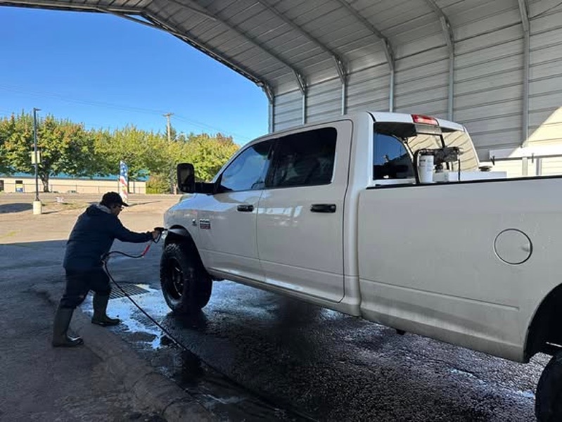Pacos Washer specialist washing a white pickup truck